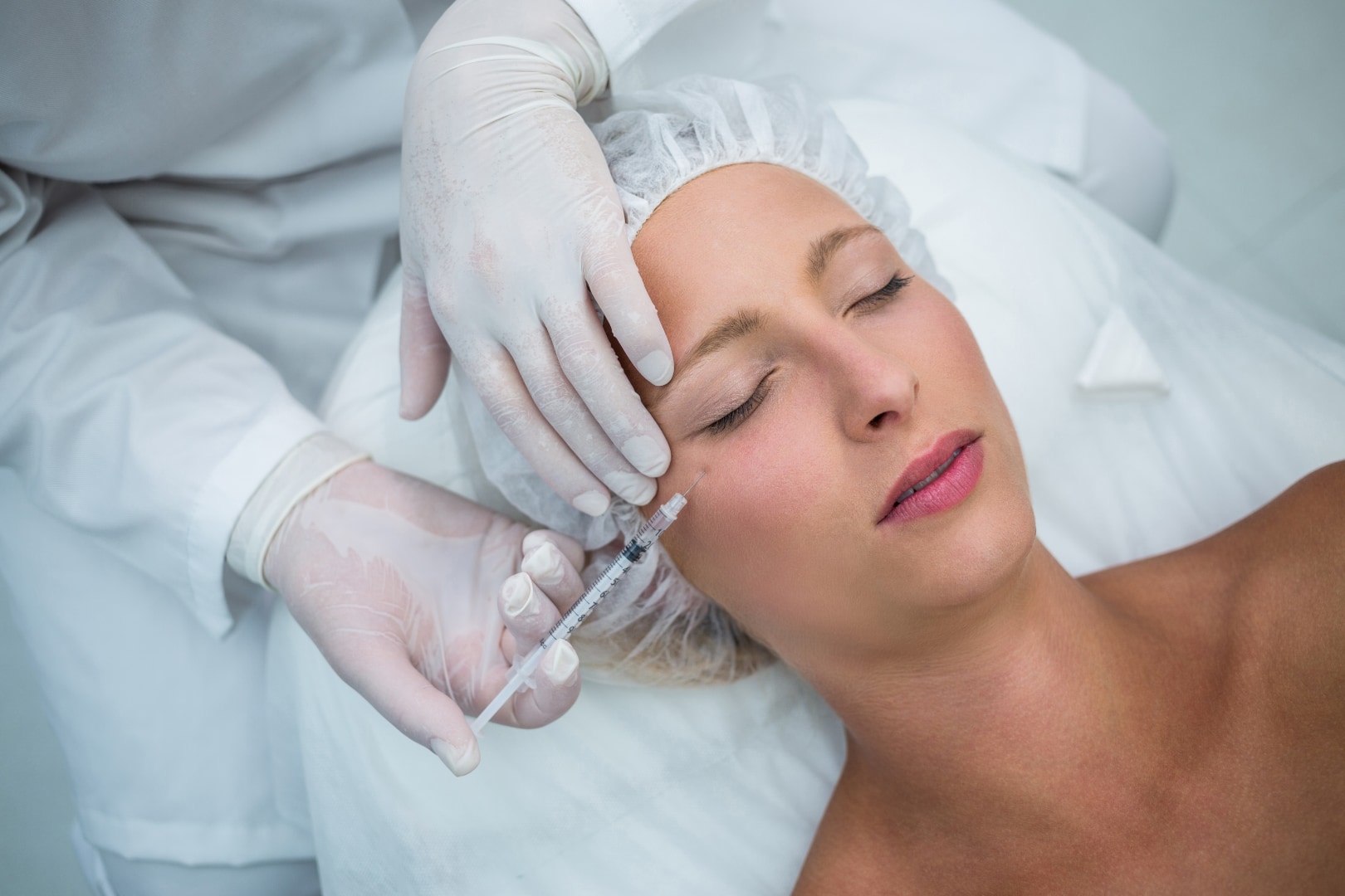 Patient receiving a botulinum toxin treatment injection to the forehead at an aesthetic clinic