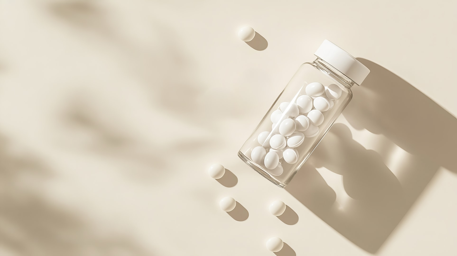 Clear glass jar of white tablets on a beige background representing PDE5 inhibitor medication