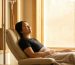 Woman resting in a recliner during a curcumin IV infusion in a sunlit clinic